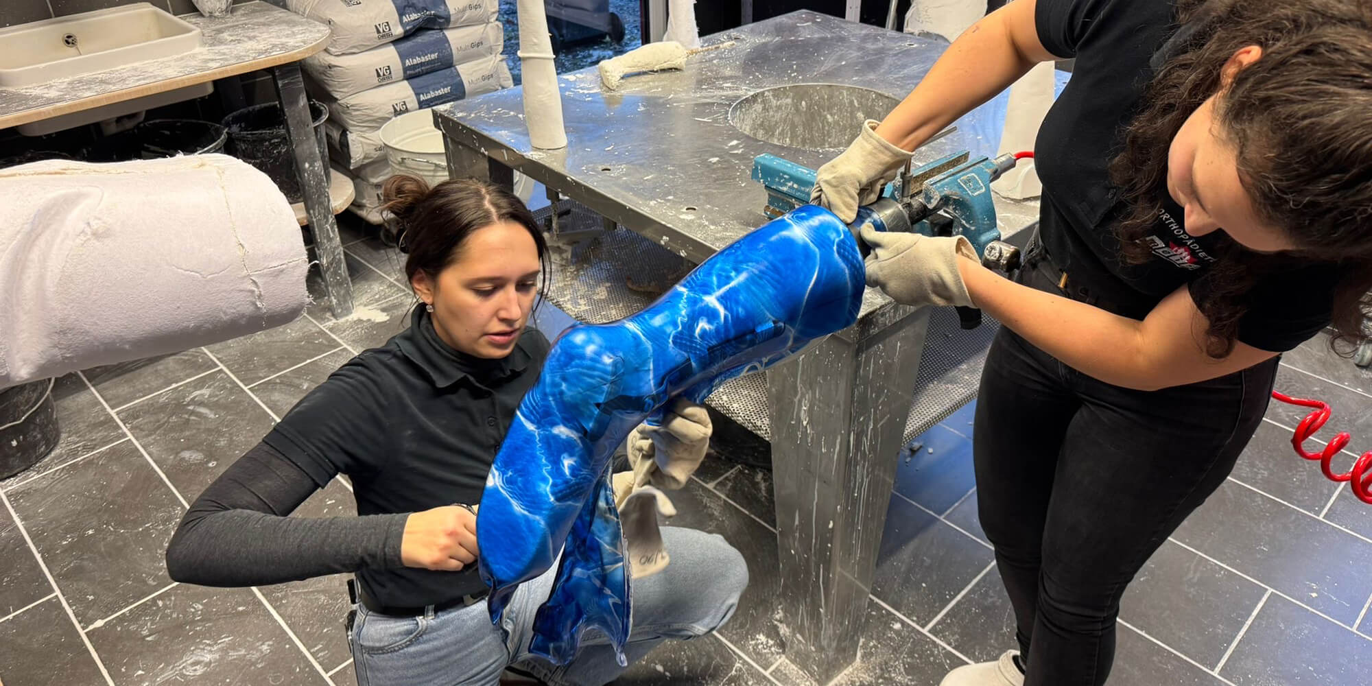 Mitarbeiterinnen bearbeiten eine individuell angepasste Orthese in der Werkstatt