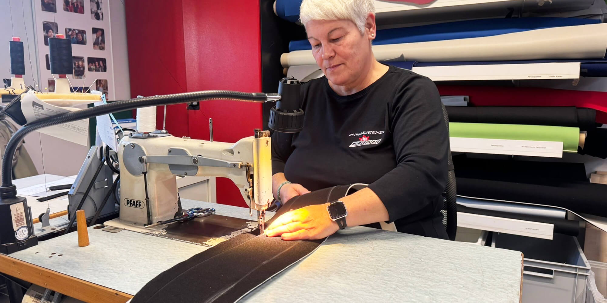 Detailaufnahme einer Orthopädietechnikerin beim Nähen eines orthopädischen Gurts.