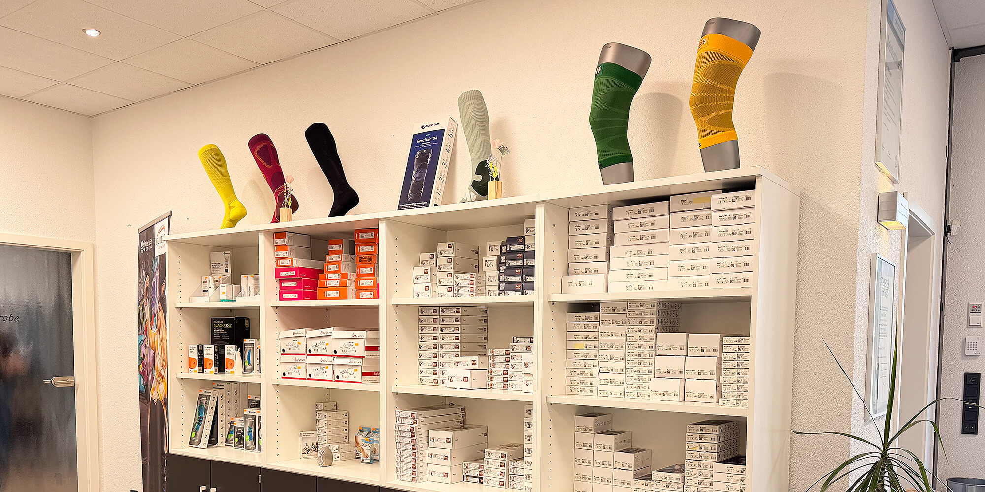 Regal mit verschiedenen medizinischen Kompressionsstrümpfen, Bandagen und Sanitätsartikeln in einem Orthopädietechnik-Fachgeschäft